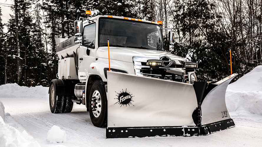 Yellow Fisher Plow attached to truck in snow